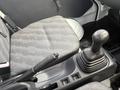 2009 Suzuki Carry featuring a textured fabric seat and a manual gear shift with a black knob in the cabin