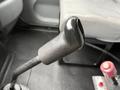 Close-up of the gear shifter in a 2006 International 4200 featuring a textured black handle and a red button on the side