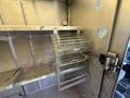 A 2012 Ford Econoline van with open shelves and metal wire storage racks hanging from one shelf