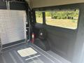 A 2022 RAM Promaster 350 interior showing a spacious cargo area with textured walls and a floor equipped with cargo tie-downs and a small backpack on the side