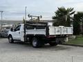 A white 2015 Ford F-350 flatbed truck with a tool bed and equipment visible on the back