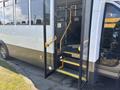 A 2020 Chevrolet Express bus with open doors revealing yellow handrails and steps for boarding