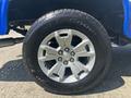 Close-up of a silver alloy wheel with five spokes and a black tire labeled BFGoodrich all-terrain featuring a Chevrolet logo in the center