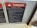 A warning label on a metal surface detailing operating hazards and safety instructions for a vehicle or machine
