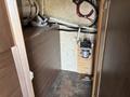 Interior view of a 2018 Westland Travelaire with visible plumbing and electrical components mounted on a wooden surface and a water pump on the floor