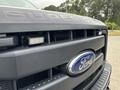 A close-up of a 2013 Ford F-250 SD grille displaying the Ford logo and a light bar integrated into the front design