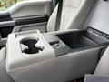 A 2020 Ford F-550 center console featuring two cup holders and a storage compartment
