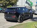 A black 2023 Fisker Ocean electric SUV with sleek lines a modern design and black alloy wheels parked on a lot