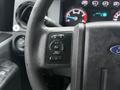 Close-up of the steering wheel controls in a 2015 Ford F-450 showing buttons for settings information and reset functions
