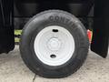 Close-up of a black tire from a 2012 International 7400 with visible treads and the brand name Continental prominently displayed on the sidewall