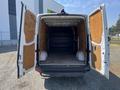 A 2016 Mercedes-Benz Sprinter van with its rear doors wide open revealing an empty cargo space and wooden paneling on the sides