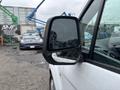 A 2019 Ford Transit Connect with a clear side mirror reflecting the surroundings and raindrops on its surface