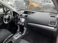 Interior view of a 2016 Subaru Forester showing the dashboard gear shift and infotainment system with a black and silver color scheme