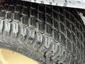 Close-up of a tire from a 2015 Kubota F3990 showcasing a rugged tread pattern with visible water droplets on its surface
