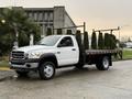 A white 2008 Sterling Bullet flatbed truck with a black bed and metal racks for transporting materials