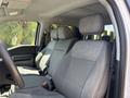 Interior of a 2021 Ford F-150 featuring two gray upholstered front seats with headrests and a black steering wheel visible in the foreground