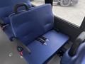 A blue bench seat with seatbelt buckles inside a vehicle designed for passenger transport