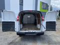 Rear view of a 2023 GMC Savana cargo van with open doors revealing an empty interior space featuring a wooden floor and metal partition