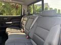 A 2017 Chevrolet Silverado 1500 with a spacious back seat featuring gray fabric upholstery and seat belts
