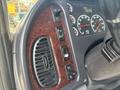 The interior dashboard of a 2010 Freightliner M2 106 featuring various control buttons gauges and a vent with a wood grain finish