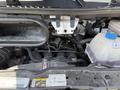 The engine compartment of a 2021 RAM Promaster showing various components including hoses a reservoir and the engine block