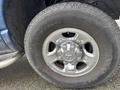 Close-up of a chrome wheel rim and tire of a 2006 Dodge Ram 2500 showing detailed tire tread and shiny hubcap design