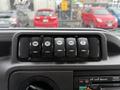 Dashboard controls of a 2014 Ford Econoline featuring six switches for various functions including lights and heating
