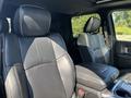 Interior of a 2018 RAM 3500 featuring two black leather front seats with adjustable headrests and a center console between them