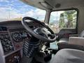 Interior view of a 2008 Kenworth T370 truck featuring a dashboard with various gauges a steering wheel and a driver's seat with fabric upholstery