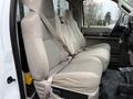 The interior of a 2008 Ford F-350 showing a spacious bench seat covered in beige fabric with seat belts attached