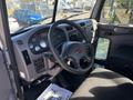 Interior view of a 2020 Peterbilt 330 featuring a steering wheel dashboard controls and seating area