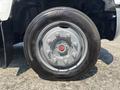 Close-up of a 2005 GMC C7500 Topkick wheel featuring a metallic silver rim with red center cap and a black tire with visible tread pattern labeled Continental