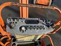 Control panel of a 2012 JLG E400AJFN aerial lift featuring various buttons levers and a digital display for operation and safety functions