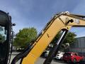 A 2022 Caterpillar 306 excavator's arm and boom showing hydraulic lines and the CAT logo with a focus on its construction equipment design