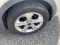 Close-up of a tire and alloy wheel on a 2015 Ford Escape showing a round design with five spokes and visible tread pattern on the tire
