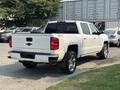 A white 2017 Chevrolet Silverado 1500 pickup truck is shown from the rear angle displaying its chrome accents and distinctive rear tailgate design