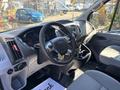 Interior view of a 2016 Ford Transit 150 featuring a steering wheel dashboard and seats with a focus on gray and black design elements