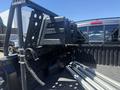 A 2010 Toyota Tacoma truck bed with a ladder rack and several aluminum ladder sections lying inside