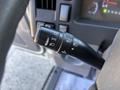 A close-up of the control stalk of a 2016 Isuzu NPR-HD featuring various switch options for lights and cruise control