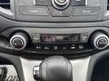 Interior controls of a 2014 Honda CR-V displaying climate control settings and audio system buttons