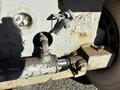 A close-up of a rusty hydraulic system on a Skyjack SJ with a hose connection and a lever for operation