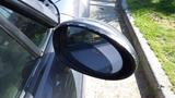A close-up of the side mirror of a 2007 Mazda Miata showcasing its sleek design and contours