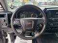 Steering wheel of a 2016 GMC Sierra 1500 with controls and the GMC logo in the center