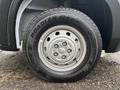 A close-up of a silver wheel on a 2023 RAM Promaster 3500 with a Roadian tire featuring a simple five-spoke design