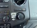 Dashboard controls of a 2013 Ford F-550 featuring buttons for air conditioning, work lights, and a 12V power outlet