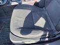 A black fabric front seat of a 2006 Pontiac G6 with a textured pattern and a visible shadow on the surface