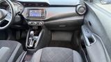 Interior view of a 2019 Nissan Kicks featuring a central touchscreen display and gear shift with seating and armrest visible