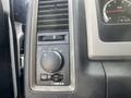 Control panel of a 2012 RAM 2500 featuring knobs and switches for lights and vents