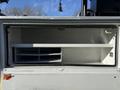 A 2009 Ford F-550 with an open storage compartment featuring several shelves and a white interior
