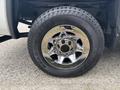 A close-up of a chrome wheel with a rugged tire labeled Road Venture APT mounted on a 2016 GMC Sierra 1500